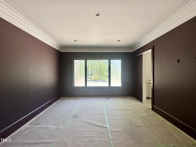 empty room with baseboards and crown molding