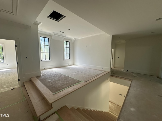 spare room with attic access, baseboards, and crown molding