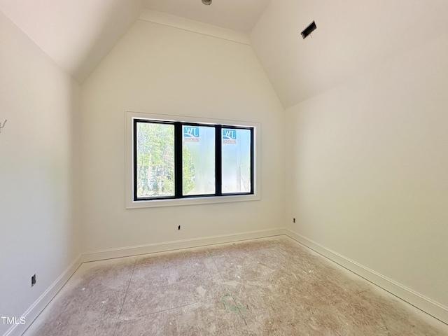 spare room with baseboards and high vaulted ceiling