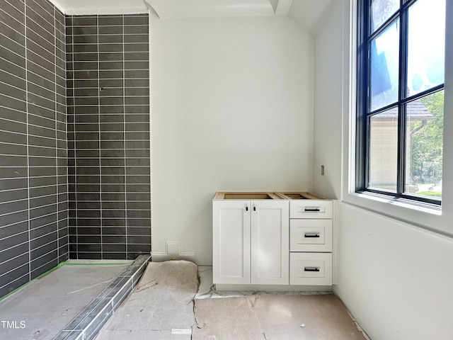 bathroom featuring a wealth of natural light and tiled shower
