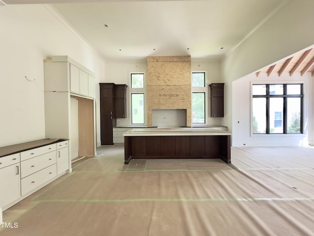 7208 Tanbark Way, Raleigh, NC 27615 - kitchen with a kitchen island, dark brown cabinets, ornamental molding, and light carpet