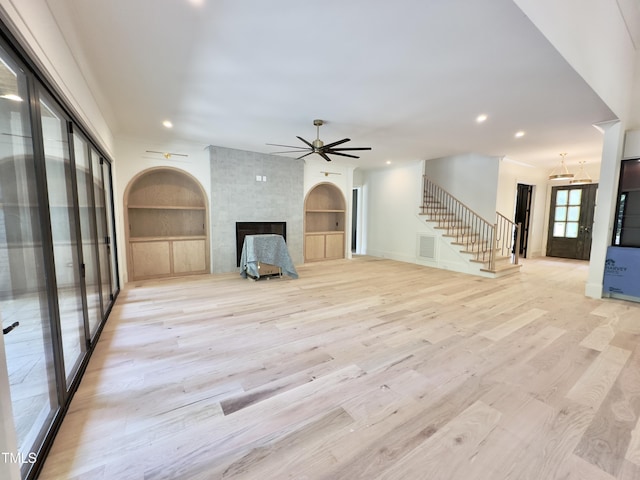7208 Tanbark Way, Raleigh, NC 27615 - unfurnished living room with stairs, a large fireplace, ceiling fan, light wood-type flooring, and recessed lighting