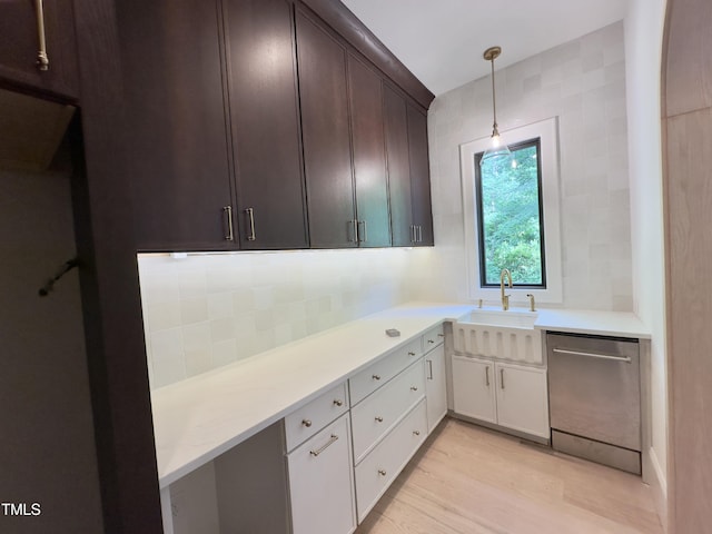 7208 Tanbark Way, Raleigh, NC 27615 - kitchen featuring stainless steel dishwasher, light countertops, light wood finished floors, dark brown cabinets, and pendant lighting