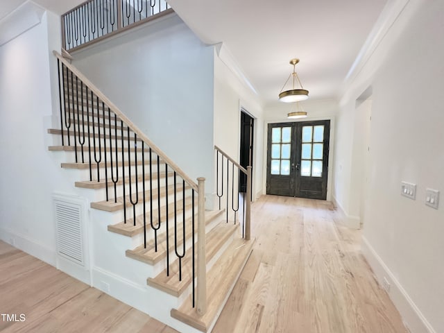 7208 Tanbark Way, Raleigh, NC 27615 - entrance foyer with french doors, wood finished floors, stairway, and ornamental molding