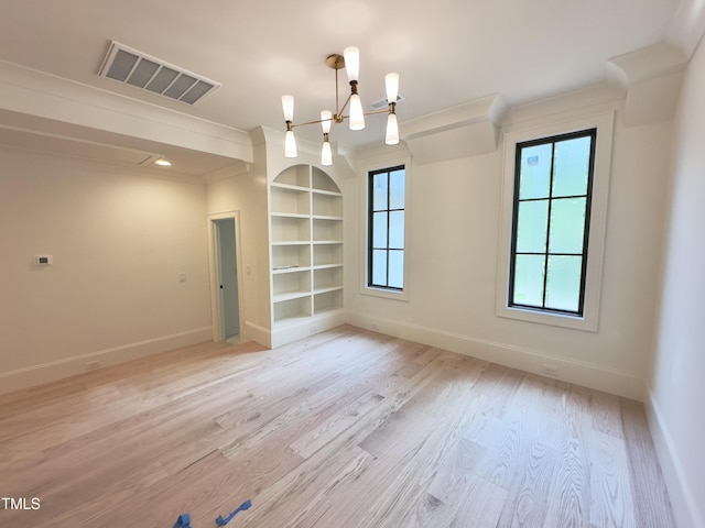 7208 Tanbark Way, Raleigh, NC 27615 - spare room with light wood-style flooring, built in shelves, a chandelier, and ornamental molding