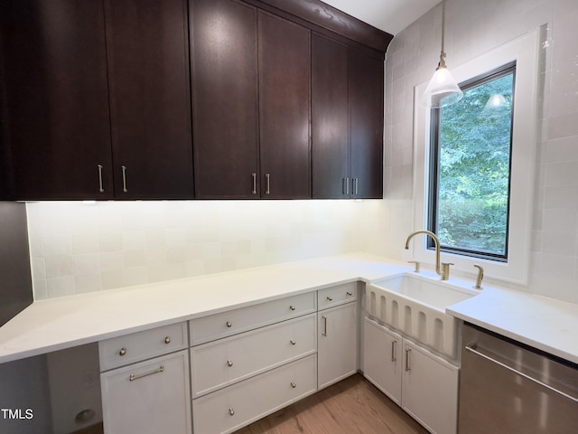 7208 Tanbark Way, Raleigh, NC 27615 - kitchen with stainless steel dishwasher, light countertops, wood finished floors, hanging light fixtures, and dark brown cabinetry