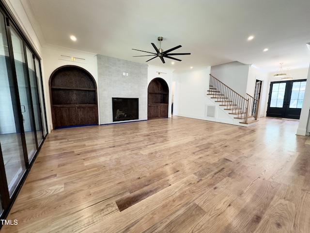 7208 Tanbark Way, Raleigh, NC 27615 - unfurnished living room with stairs, a ceiling fan, light wood-type flooring, recessed lighting, and french doors