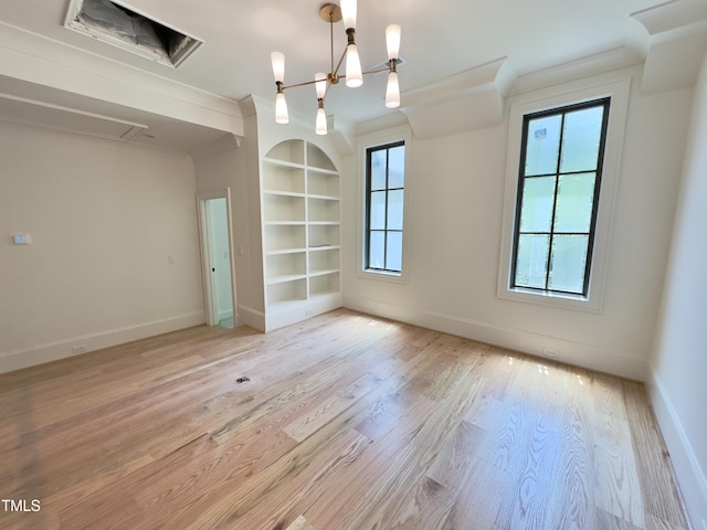 7208 Tanbark Way, Raleigh, NC 27615 - spare room with built in shelves, healthy amount of natural light, light wood-style floors, a chandelier, and ornamental molding