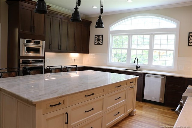 kitchen featuring light wood-type flooring, sink, stainless steel appliances, and backsplash