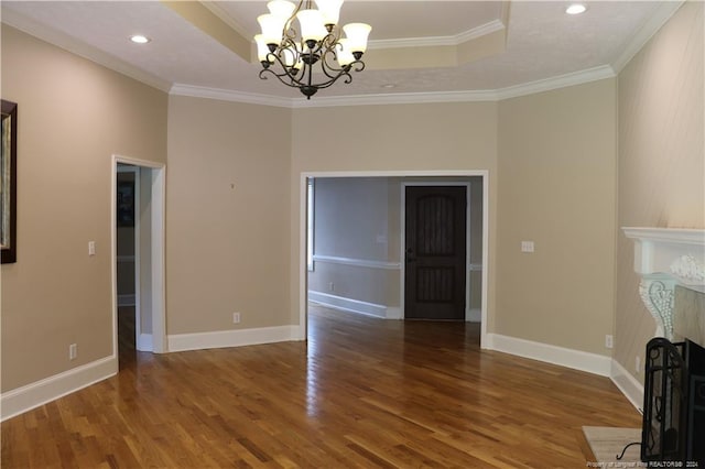 unfurnished living room featuring a raised ceiling, a chandelier, hardwood / wood-style flooring, and crown molding