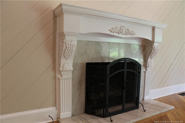 details featuring hardwood / wood-style flooring and a high end fireplace