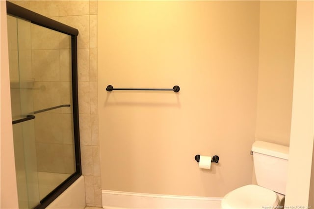 bathroom with shower / bath combination with glass door and toilet