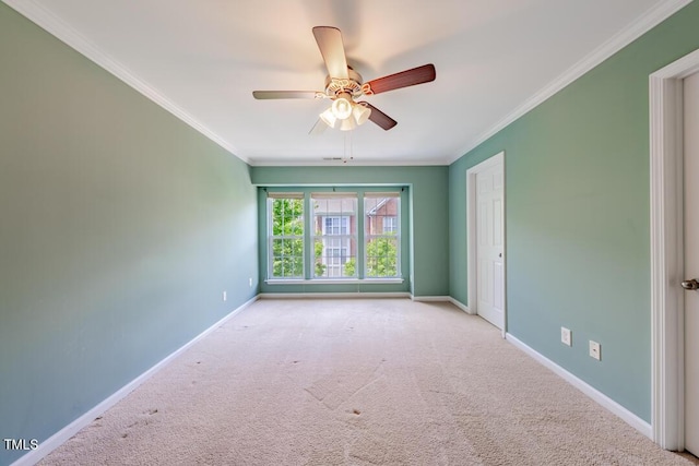 empty room featuring crown molding, light carpet, and ceiling fan