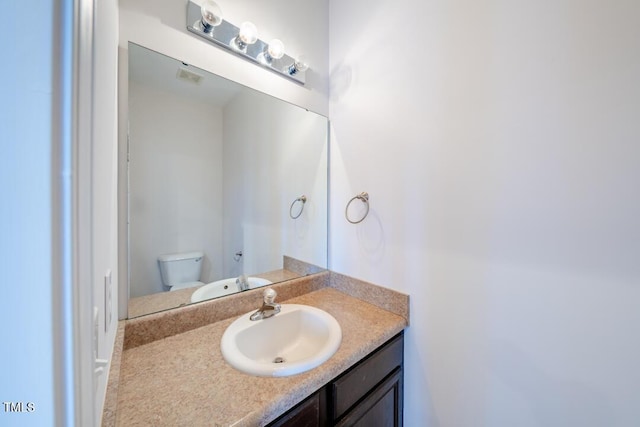 bathroom featuring vanity and toilet