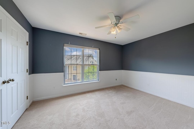 empty room with light carpet and ceiling fan