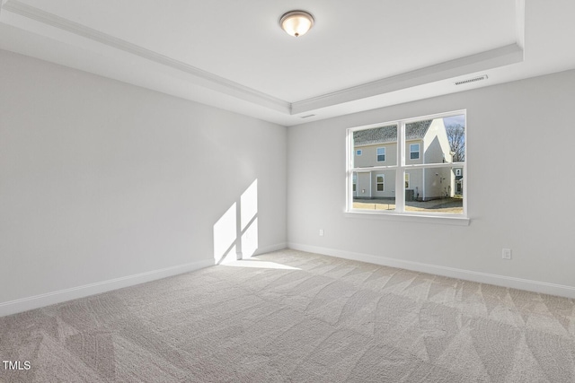 carpeted spare room with a tray ceiling