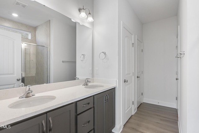 bathroom with an enclosed shower, vanity, and hardwood / wood-style flooring