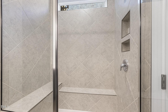 bathroom with a shower with door