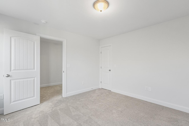 unfurnished bedroom with a closet and light carpet