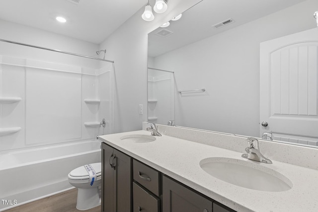 full bathroom with shower / bath combination, hardwood / wood-style floors, vanity, and toilet