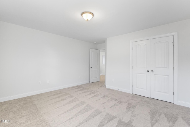 unfurnished bedroom with a closet and light carpet