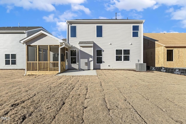 rear view of property with cooling unit, a patio area, and a sunroom