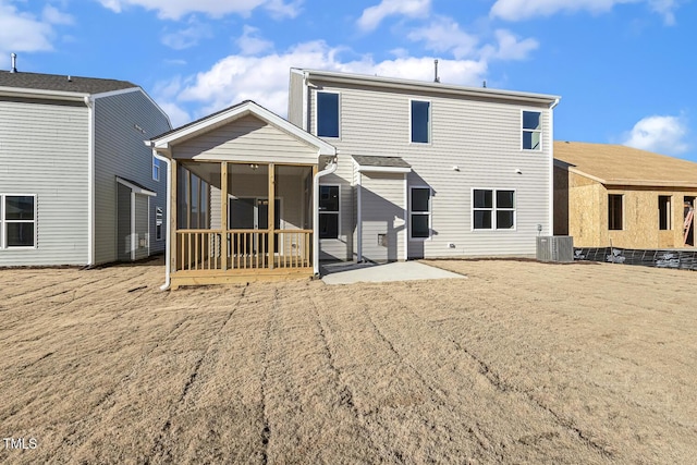 rear view of property with cooling unit, a sunroom, and a patio