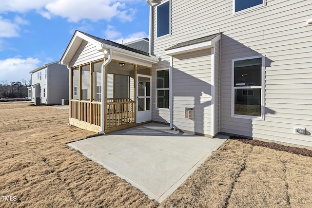 view of side of home featuring a patio area and a sunroom