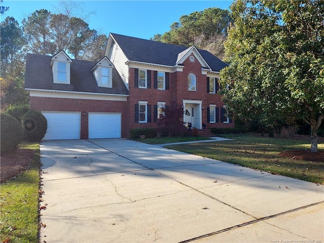 colonial inspired home with a front lawn and a garage