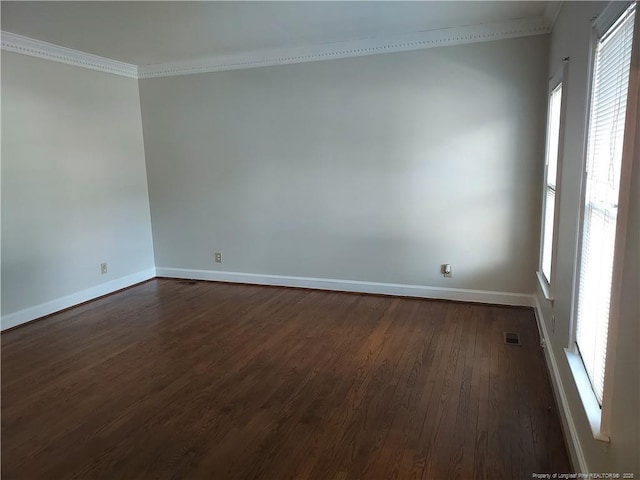 spare room featuring dark hardwood / wood-style flooring, a healthy amount of sunlight, and crown molding