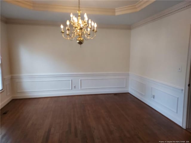 spare room featuring a notable chandelier, crown molding, dark hardwood / wood-style floors, and a tray ceiling