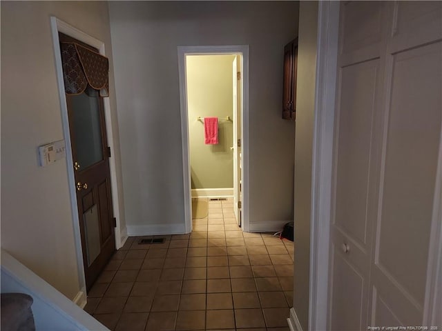 hall with tile patterned floors