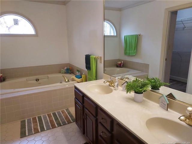 bathroom featuring vanity, tile patterned floors, ornamental molding, and tiled bath