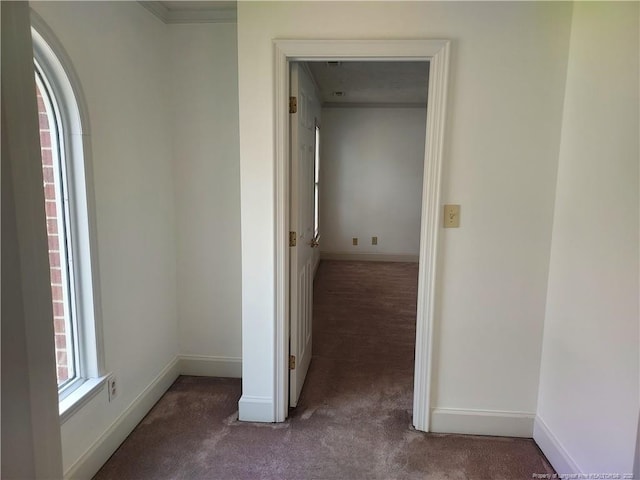 hall with dark colored carpet