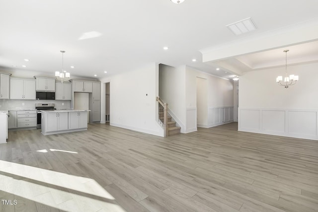 kitchen with electric range, pendant lighting, crown molding, and a kitchen island