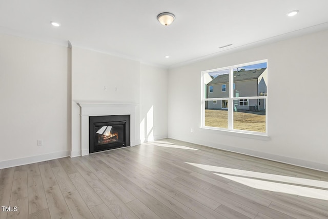 unfurnished living room with light wood-type flooring and ornamental molding