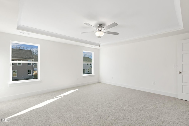 empty room featuring ceiling fan, carpet, and a tray ceiling