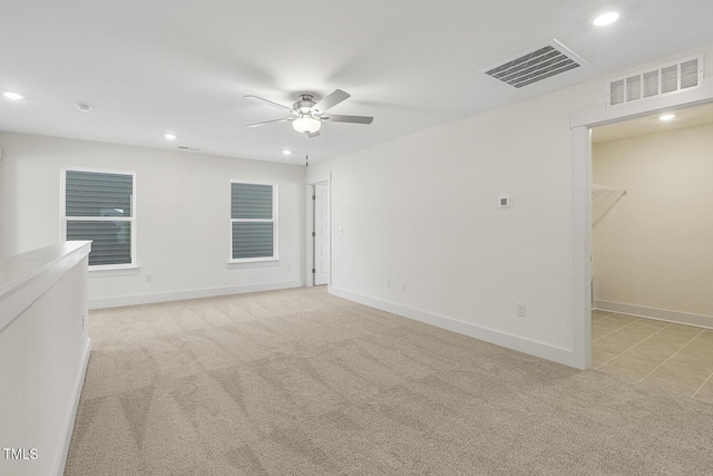 unfurnished room with ceiling fan and light carpet