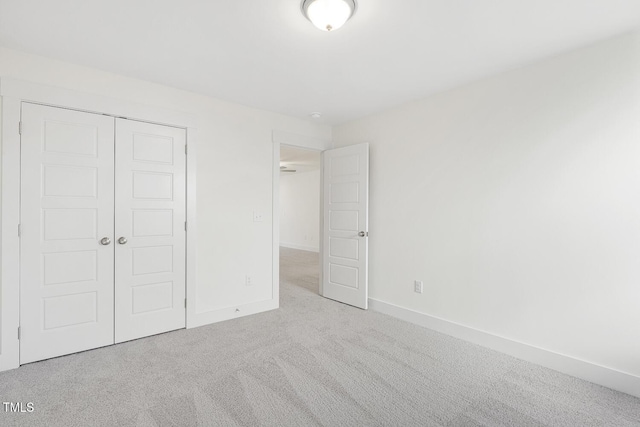 unfurnished bedroom with a closet and light carpet