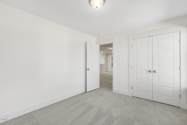 unfurnished bedroom with a closet and light carpet