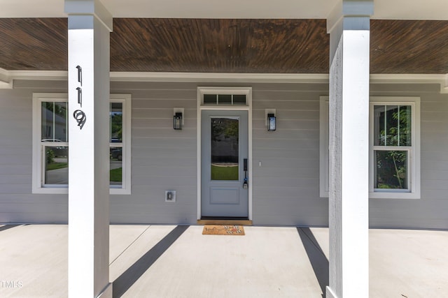 view of exterior entry featuring covered porch