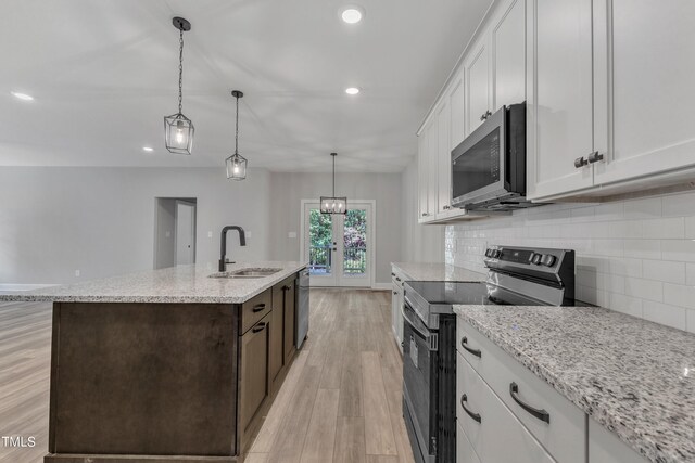 kitchen with sink, an island with sink, white cabinets, and appliances with stainless steel finishes