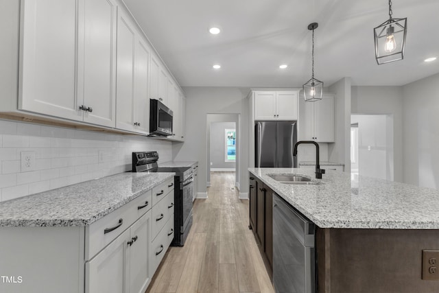 kitchen with white cabinetry, hanging light fixtures, stainless steel appliances, and sink