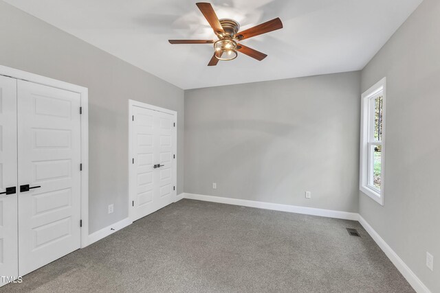 unfurnished bedroom featuring ceiling fan and carpet