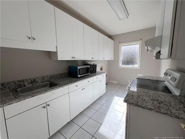 kitchen with extractor fan, sink, light tile patterned floors, stove, and white cabinetry