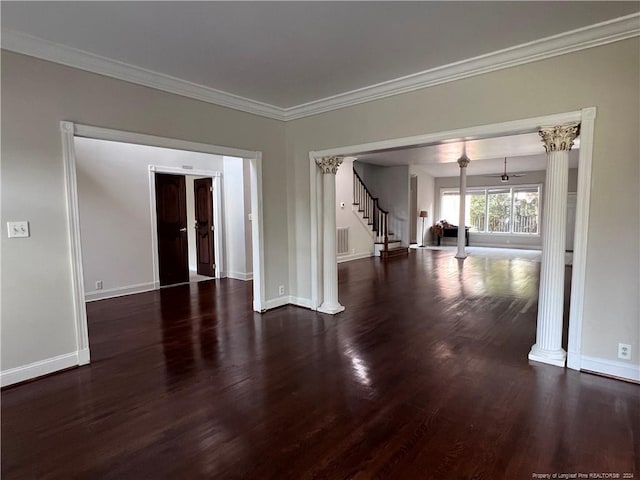 spare room featuring decorative columns, ornamental molding, an inviting chandelier, and dark hardwood / wood-style floors