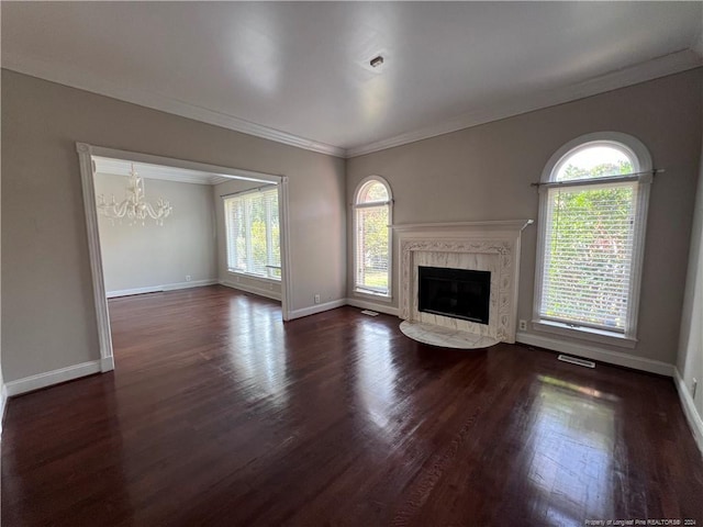 unfurnished living room featuring a premium fireplace, a notable chandelier, ornamental molding, and dark hardwood / wood-style flooring