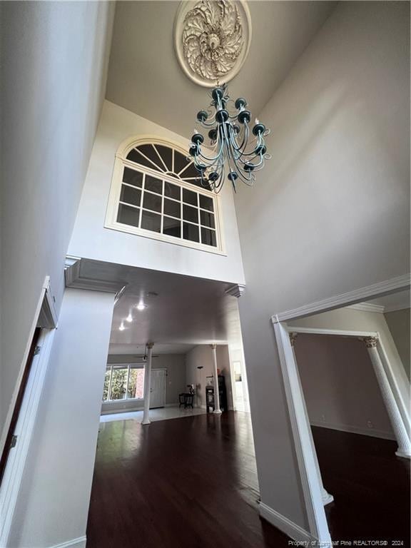 foyer featuring a chandelier, wood-type flooring, and a towering ceiling