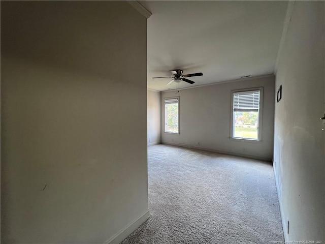 spare room featuring crown molding, light colored carpet, and ceiling fan