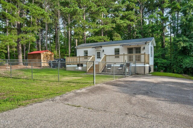 manufactured / mobile home with a front yard and a wooden deck